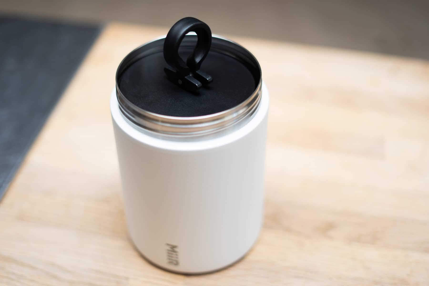 Top view of a white Miir coffee canister sitting on a cutting board