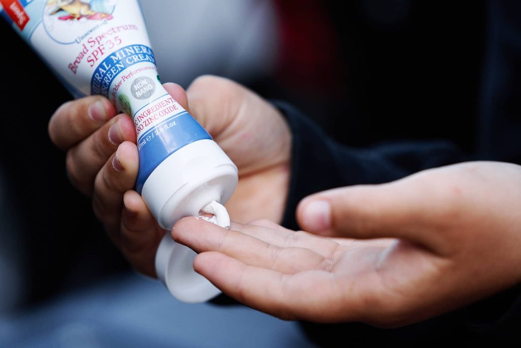 Squeezing sunscreen from the bottle on to the fingertips