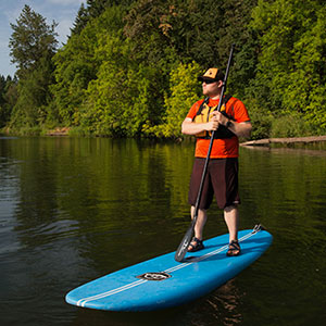 Tony standing on a paddle board in a river