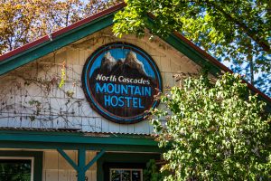 The North Cascades Mountain Hostel sign on the front of the house