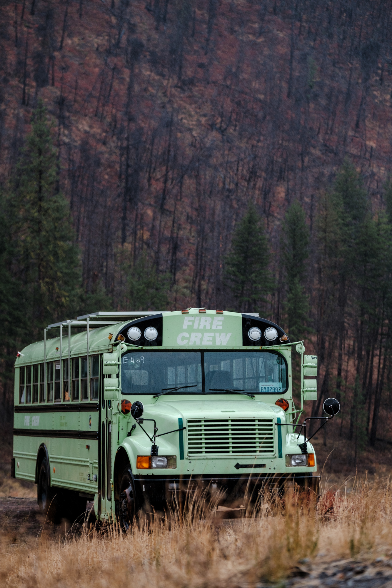 A bus marked Fire Crew in front of a scorched hillside