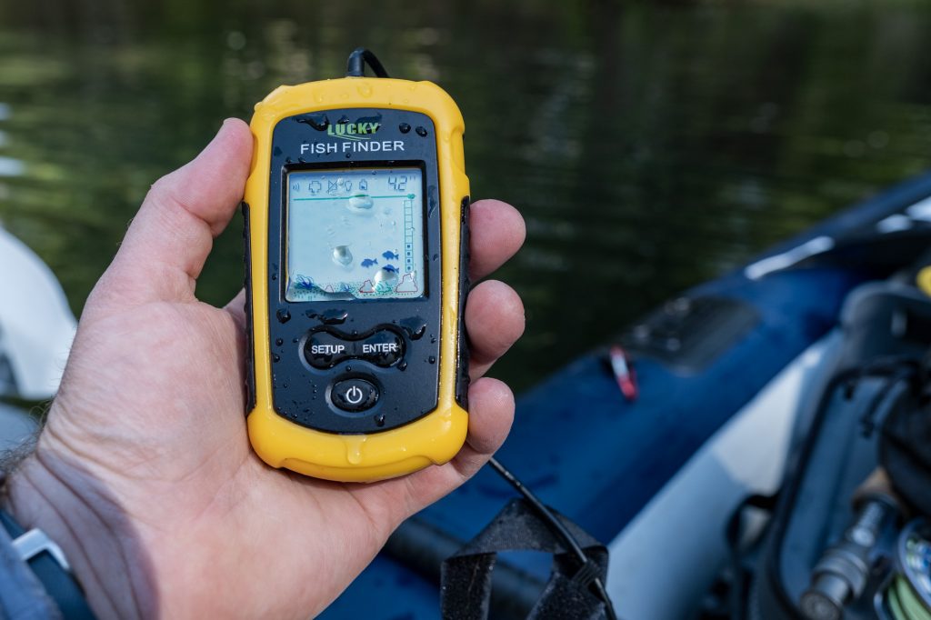 A yellow Lucky Fish Finder in the hand of a kayaker