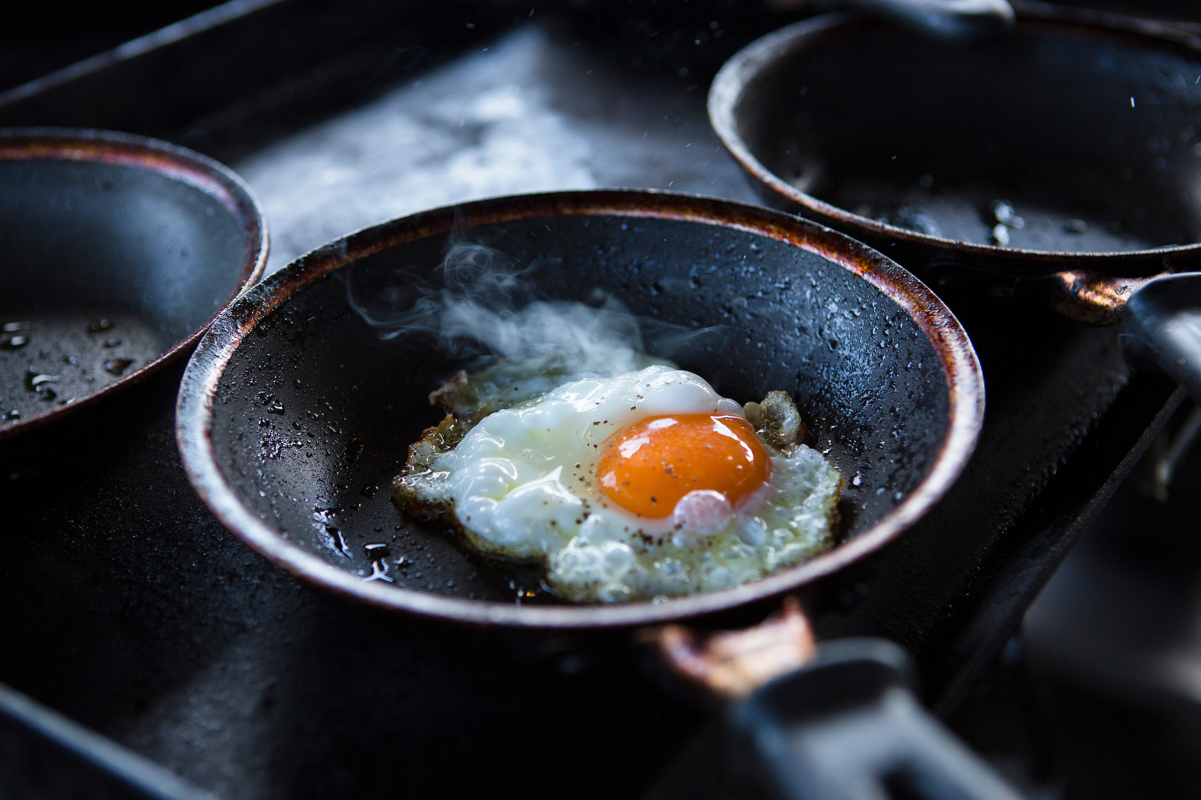 A single egg frying in a pan at Hook & Fork in Union, Washington