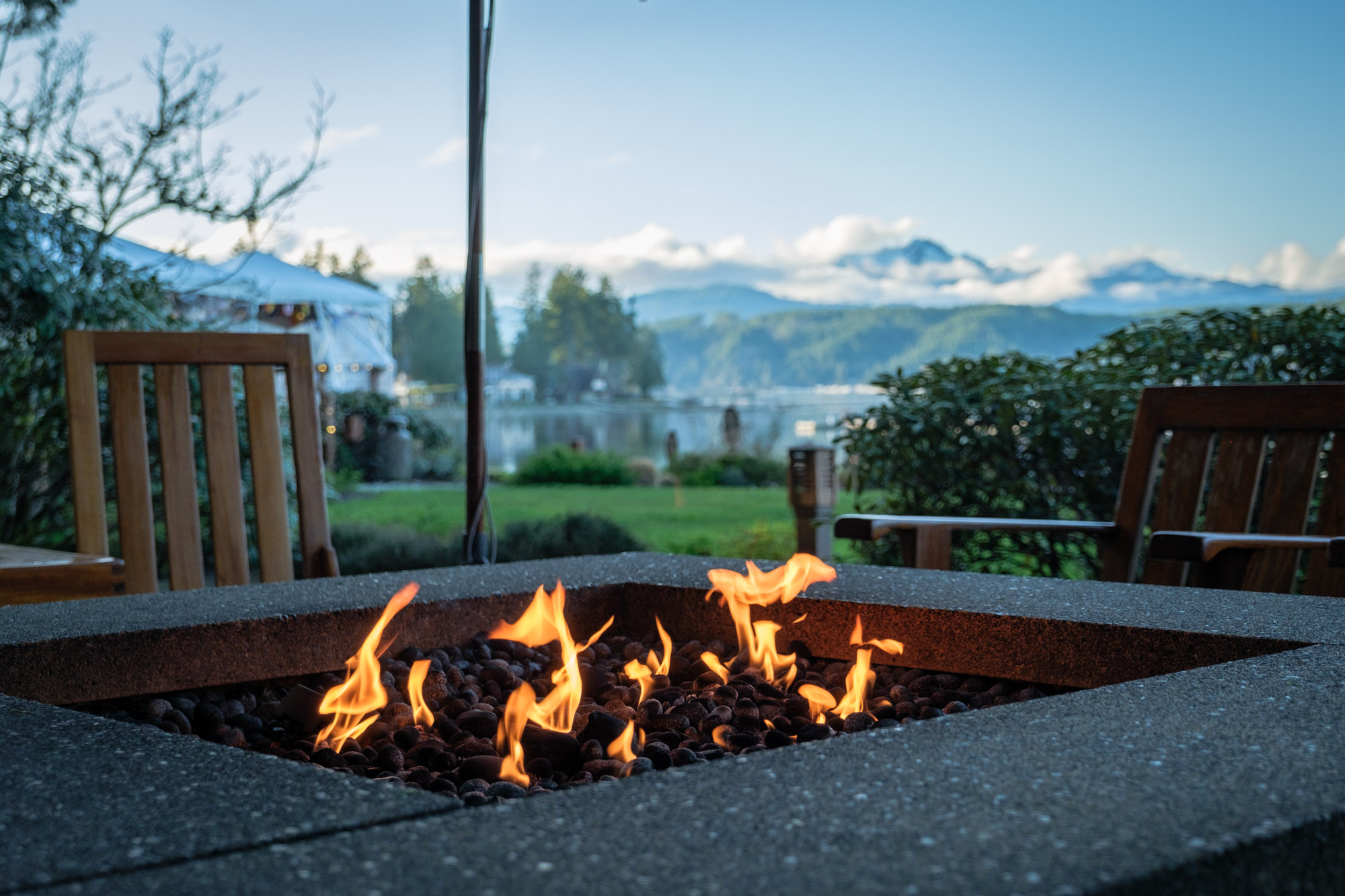 A fire pit burning in front of a view of the Olympic Mountain range in Washington state