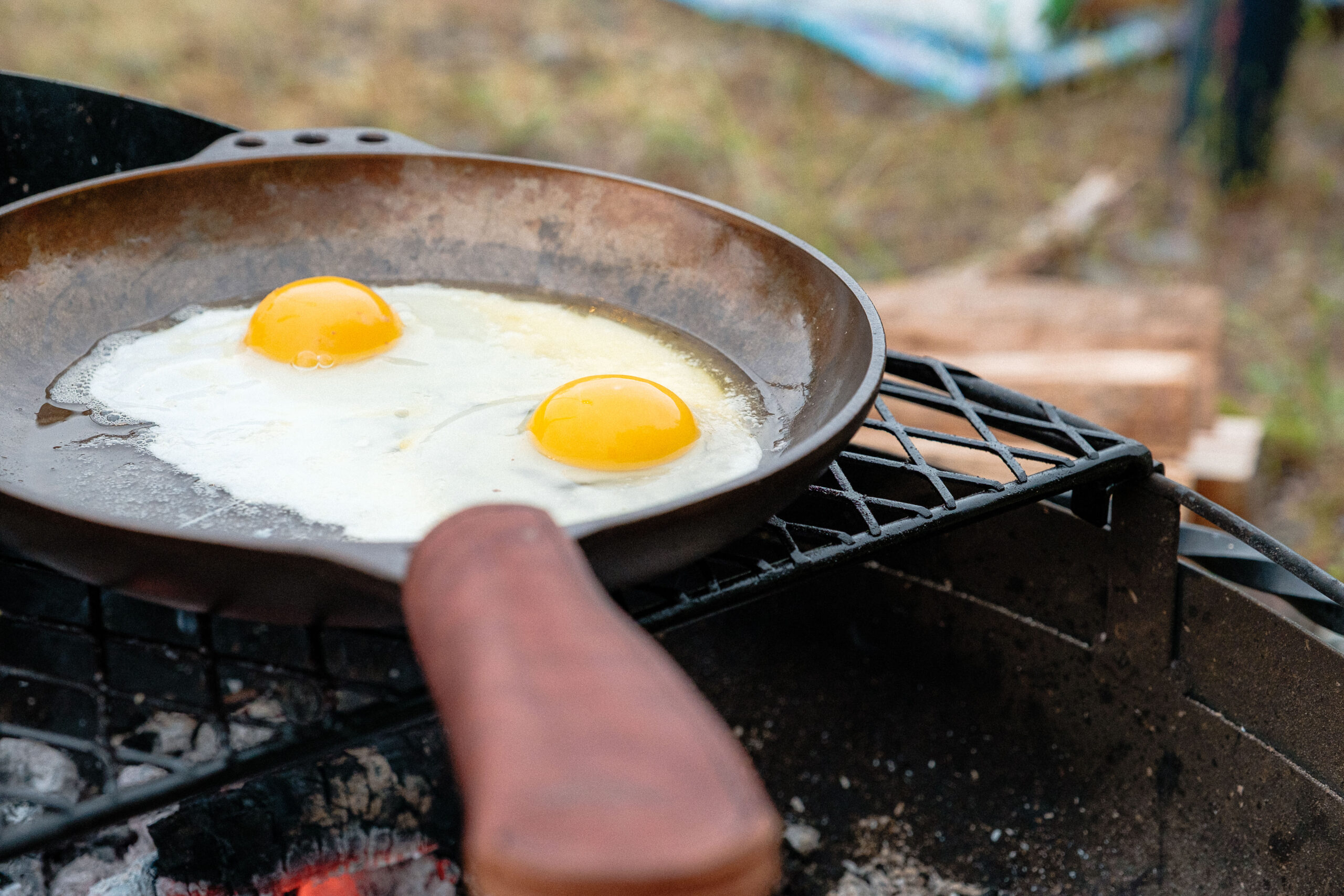 Two sunny side up eggs cooking in a Smithey cast iron pan